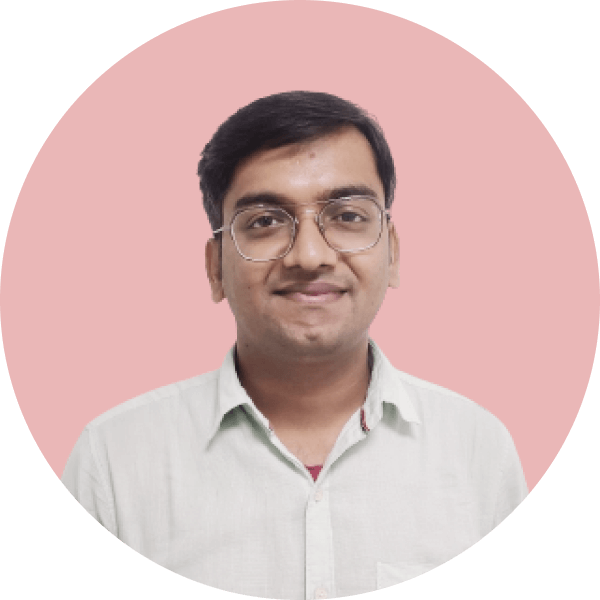 Portrait of a man with glasses wearing a light-colored shirt, smiling against a pink background.