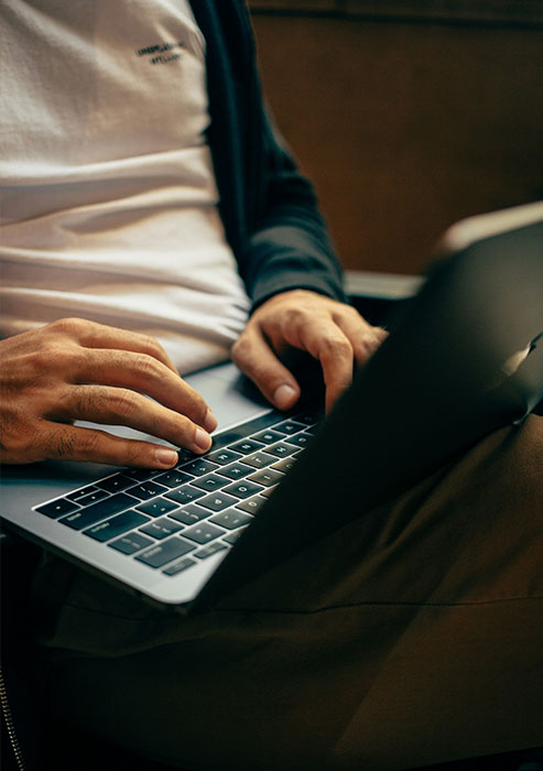 image of a man typing on laptop keypad
