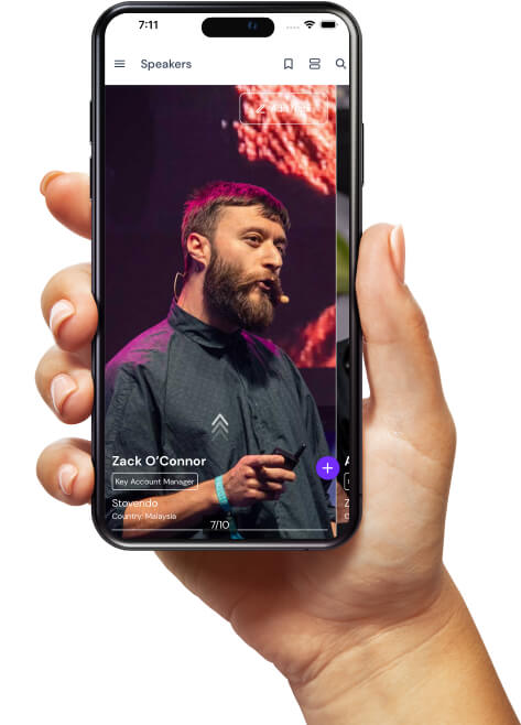 Hand holding smartphone displaying a speaker profile of Zack O'Connor, Key Account Manager from Malaysia, with a purple background image.